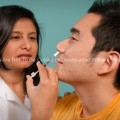 Hispanic Female Nurse Giving Nasal Spray Vaccine to Asian Patient
