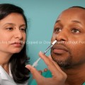 Hispanic Female Nurse Giving Nasal Spray Vaccine to African American Patient