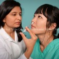 Hispanic Female Nurse Giving Nasal Spray Vaccine to a Patient