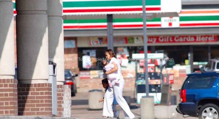 Woman carrying child into a store