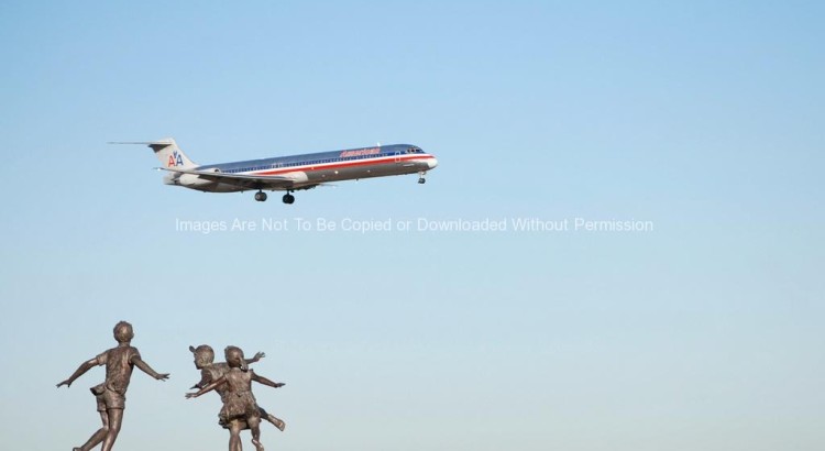 Statue at DFW Airport with Plane Flying Overhead